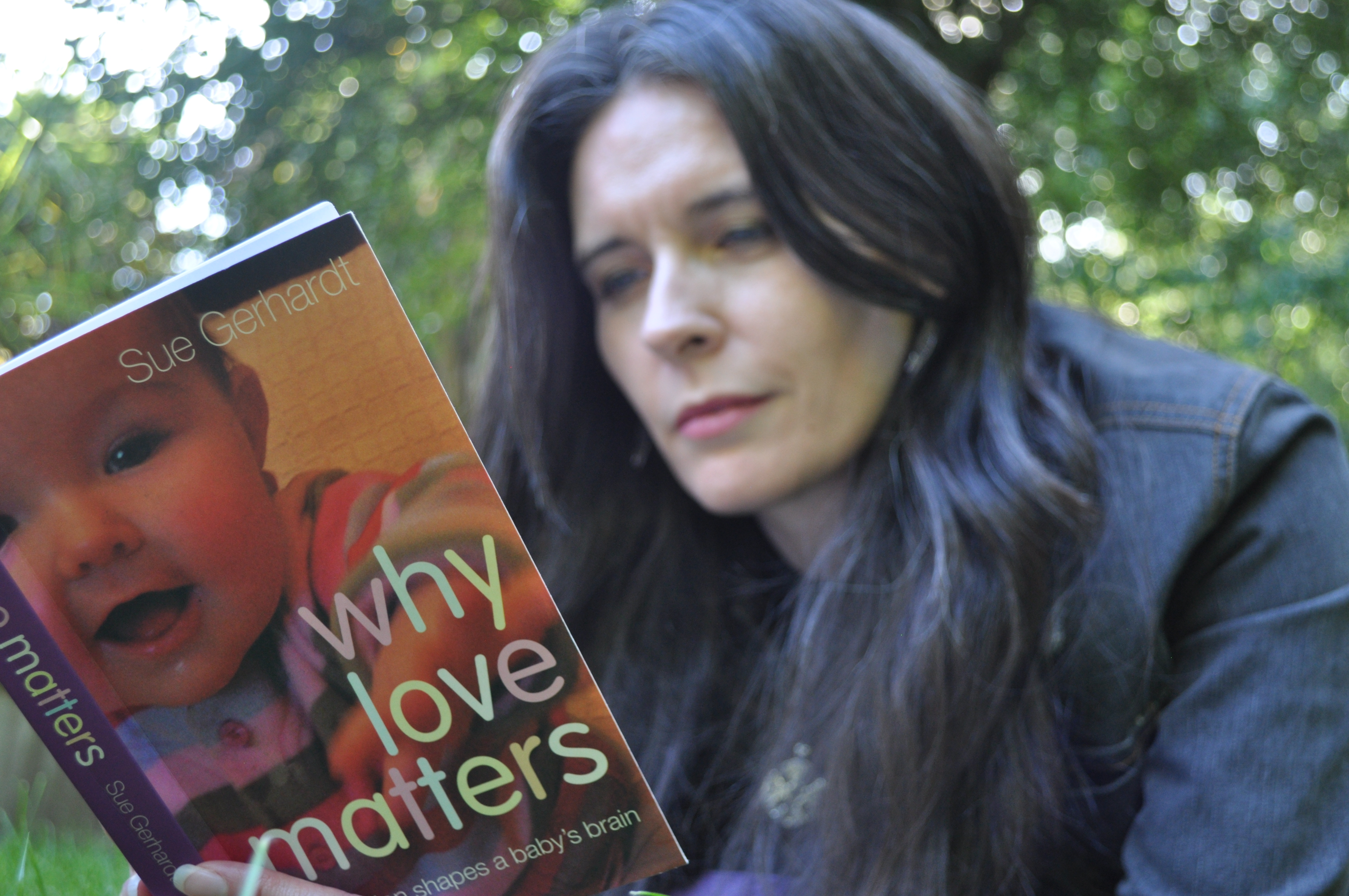 Jacqui McGinn (caucasian female with long dark hair) reads the book "why love matters".